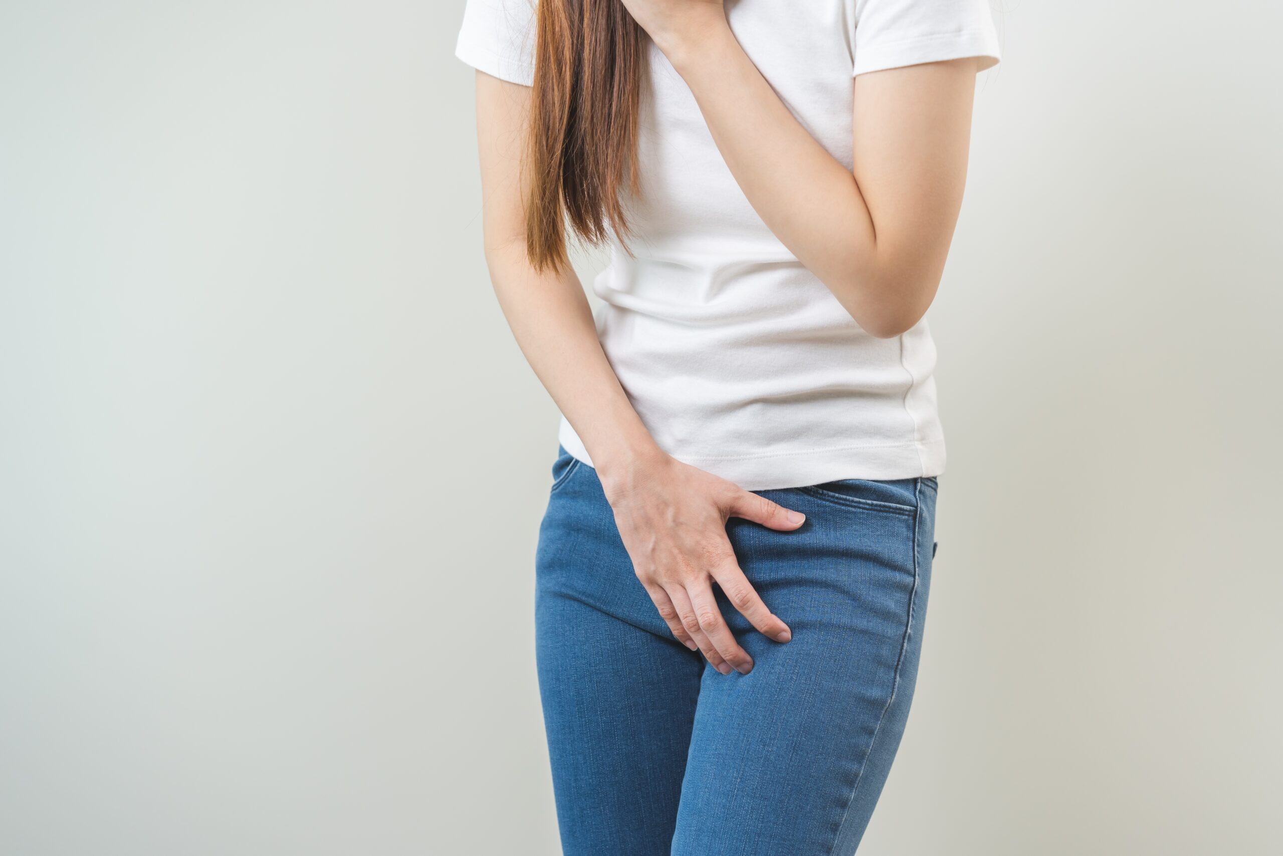 尿漏れが不安で下腹部に手を当てる女性